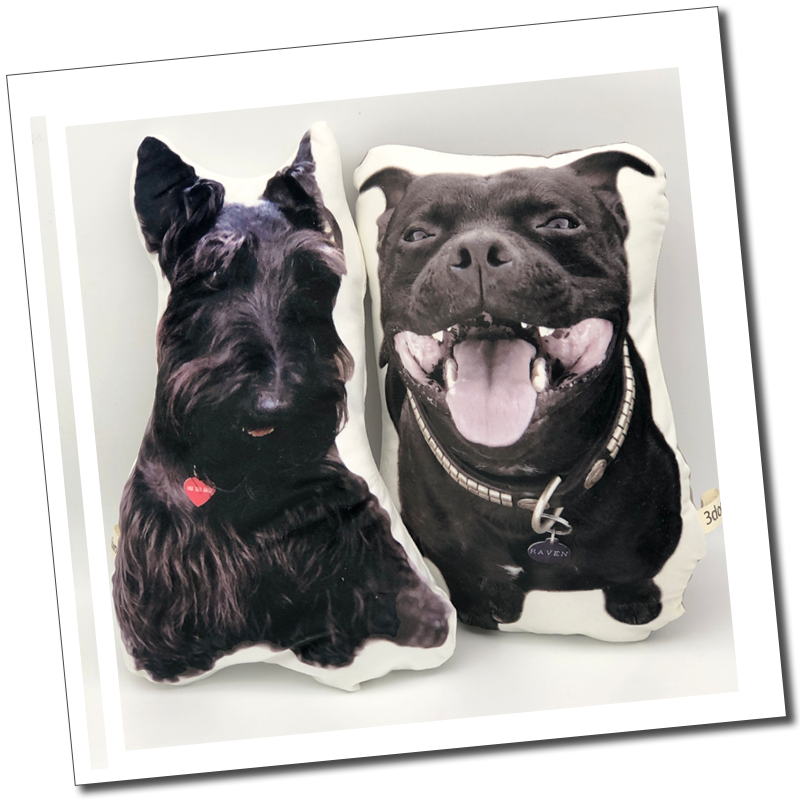 Two black dog cushions: “Two personalised cut-out pet cushions featuring a black Scottish terrier and a smiling short-haired black dog.”